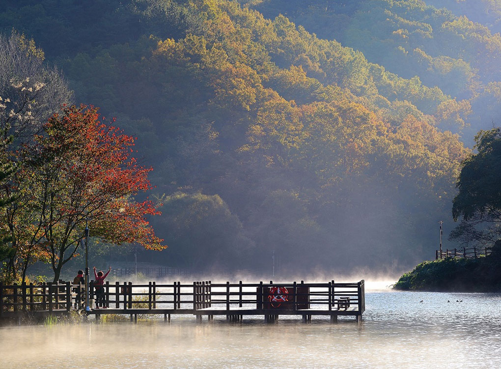 송정박상진호수공원 : 자연경관이 아름다운 호수 공원에서 산을 바라보며 산책을 즐기는 시민들의 모습입니다.